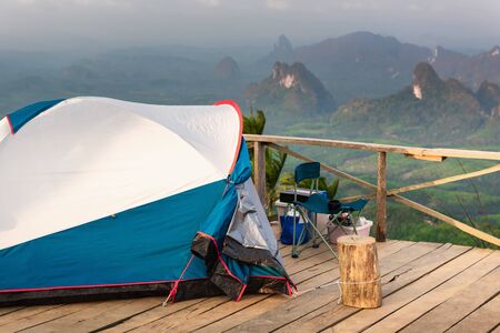 Landscape Scenery Mountains View With Camping Tent on Wooden Terrace for Outdoors Leisure Activity Relaxation. Beautiful Scenic of Nature From Campsite Viewpoint, Adventure/Vacation Lifestyle Concept.の写真素材