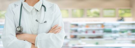 Medical Doctor or Pharmacist Healthcare in Pharmacy Shop, Physician Doctor Standing and Arm Crossed in front of Medicine Drugstore. Medic Health Care and Apothecary Pharmaceutical Occupation Concept.の写真素材