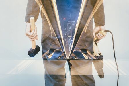 Double Exposure Images of Construction Worker Holding Constructing Equipment Tools and Infrastructure Bridge Road With Cityscape Background. Business Engineering Industry and Engineer Jobs Occupationの写真素材