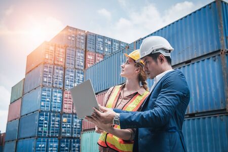 Business Team Container Cargo Shipping Control Inspection Loading Dock and Management Import/Export Freight at Port Ship Yard. Manager and Foreman Teamwork Inspecting Containers Shipment Warehouse.の写真素材