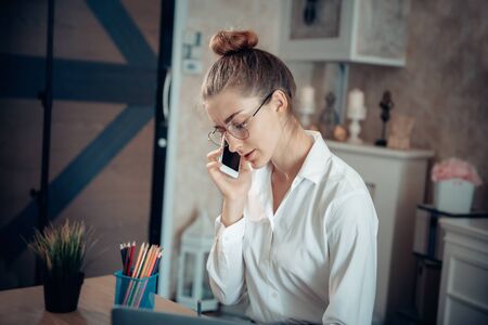 Work From Home Lifestyle and Business Online, Attractive Woman Hands is Calling on Mobile Phone While Working at Home. Business Freelance Person Using Computer Laptop at Her Home Workplace, New Normalの写真素材