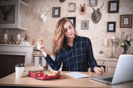 Busy Businesswoman Work at Home While Working on Table Desk With Laptop at The Same Time She Eating, Business Woman Entrepreneur Work From Home With Serious Communicating Busy Tasking. Work Lifestylesの写真素材