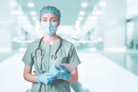 Medical Surgical Doctor and Health Care, Portrait of Surgeon Doctor in PPE Equipment in Examination Room. Medicine Female Doctors Wearing Face Mask and Cap for Patients Surgery Work. Medic Hospitalの写真素材