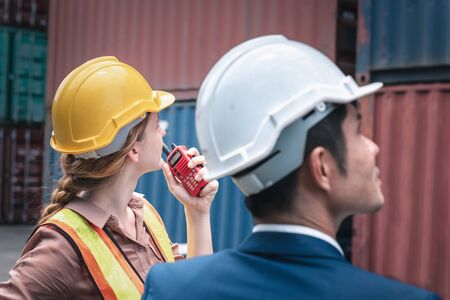 Business Team Container Cargo Shipping Control Inspection Loading Dock and Management Import/Export Freight at Port Ship Yard. Manager and Foreman Teamwork Inspecting Containers Shipment Warehouse.の写真素材