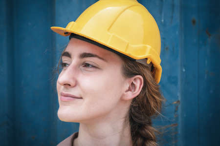 Portrait of Confident Transport Engineer Woman in Safety Equipment Standing in Container Ship Yard. Transportation Engineering Management and Container Logistics Industry, Shipping Worker Occupationの写真素材