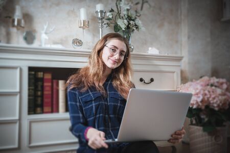 Young Woman Working on Computer Laptop at Home, Businesswoman in Happy Smiling While Online Virtual Conversation on Laptop From Home. Technology Communication and Creative Work at Home Conceptの写真素材