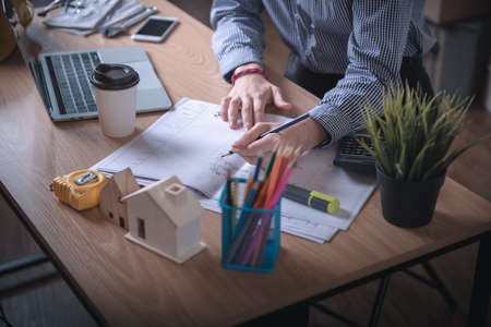 Architect Woman is Working Architecture Drawing Layout and Detail Drafing on Table Desk in Home Office, Female Designer is Creative Sketching for Construction. Architects Occupation/Creativity Conceptの写真素材