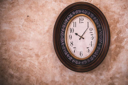 Classic Antique Clock Hanging on Isolated Retro Wall Background, Vintage Ellipse Timer Clock.の写真素材
