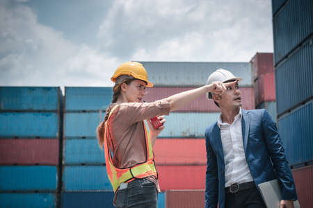 Container Shipping Logistics Engineering of Import/Export Transportation Industry, Transport Engineers Teamwork Controlling Management Containers Together at Port Ship Loading Dock. Business Teamの写真素材