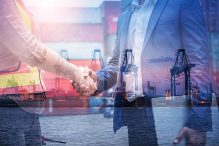 Double Exposure of Businessman and Container Shipping Worker Greeting Handshake Together With Containers Cargo Ship Port Terminal. Transportation Freight for Import/Export of Shipment Service Industryの写真素材