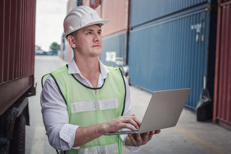 Container Supervisor Control Import/Export While Inspecting Containers Box in Warehouse Storage Distribution. Container Logistics Shipping Controlling of Transportation Industry, Cargo Ship Factoryの写真素材