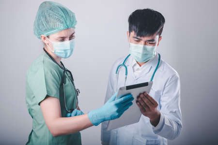 Doctor Team Discussion Patient Diagnosis Report on Tablet Against Patients Ward Background, Group of Doctors Teamwork in Medical Equipment Working in Clinic Surgical Hospital. Healthcare/Medicineの写真素材