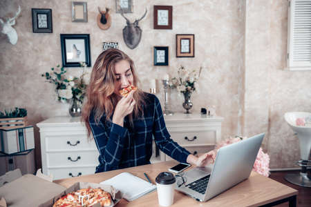 Busy Businesswoman Work at Home While Working on Table Desk With Laptop at The Same Time She Eating, Business Woman Entrepreneur Work From Home With Serious Communicating Busy Tasking. Work Lifestylesの写真素材