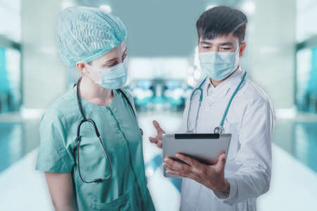 Doctor Team Discussion Patient Diagnosis Report on Tablet Against Patients Ward Background, Group of Doctors Teamwork in Medical Equipment Working in Clinic Surgical Hospital. Healthcare/Medicineの写真素材