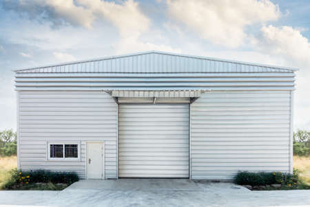 Steel Shutter Roller Door of Factory Warehouse Workshop for Materials Storage, Front View of Rolling Metal Doors for Access and Security. Gate Building Structure of Warehouses for Storeの写真素材