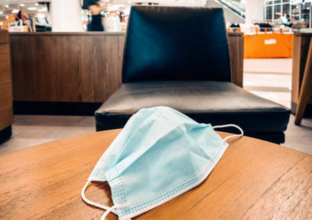 Medical Face Mask for Health care and Virus Protection on Cafe Desk in Coffee Shop. Prevention Disease From Pandemic Situation. Healthcare and Medicine Conceptの写真素材