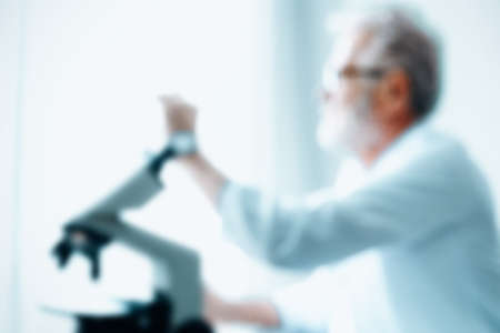 Abstract Motion Blurred of Senior Scientist Researcher Using Microscope in Laboratory, Defocus Blurry of Male Chemist Research is Studying Experiment Bacteria With microscopically in Lab.の写真素材
