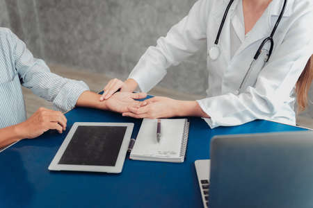 Close-Up of Physician Doctor is Examining Physical Symptom of Senior Patient in Examination Room, Practitioner Female Doctor is Diagnosing Health Checkup for Elder Old Man, Healthcare and occupationの写真素材