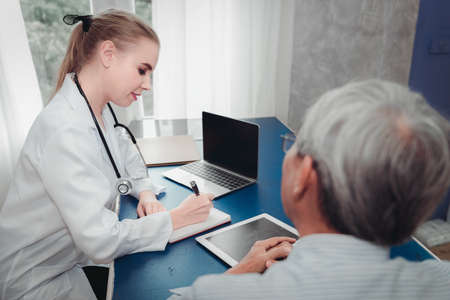 Portrait of Physician Doctor is Examining Physical Symptom of Senior Patient in Examination Room, Practitioner Female Doctor is Diagnosing Health Checkup for Elder Old Man, Healthcare and occupationの写真素材