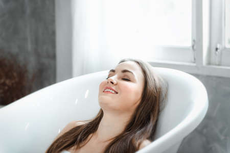 Portrait of Pretty Woman Relaxing in a Bathtub, Close-Up of Caucasian Woman Happiness and Relaxed in Bath-tub for Beauty Skincare and Bathing at Resting Room. Health Care/Lifestyles Conceptの写真素材