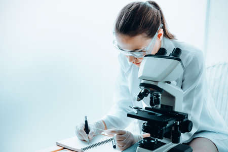 Laboratory Research Scientist Working With Microscope Testing Equipment in Lab, Professional Female Scientist Analyzing Genetic Disease on Microscopes in Clinic Lab. Medical Healthcare/Biology Scienceの写真素材