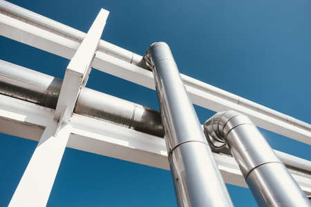 Cooling Chiller or Steam Pipeline and Insulation of Manufacturing in Oil and Gas Industrial, Petrochemical Distribution Pipe at Refinery Plant. Overhead Steel Pipe Support on Blue Sky Background.の写真素材