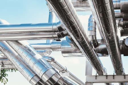Cooling Chiller or Steam Pipeline and Insulation of Manufacturing in Oil and Gas Industrial, Petrochemical Distribution Pipe at Refinery Plant. Overhead Steel Pipe Support on Blue Sky Background.の写真素材