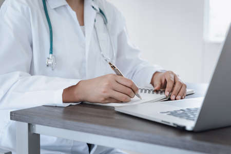 Female Physician Doctor Working at Her Desk in Examination Room, Close-Up Portrait of Medical Doctor Consulting and Diagnose Disease Patient at Clinic Hospital. Business Healthcare/ Health Medicineの写真素材