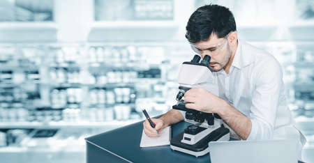 Male Research Medical Scientist Working With Microscope Testing Equipment in Laboratory, Professional Scientist Analyzing Biochemical Samples on Microscopes in Clinic Lab. Medical Healthcare/Scienceの写真素材