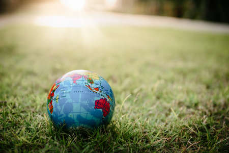 Save The Earth and Care Environment Concept, Close-up of Mockup Global on The Grass Field. Protection The Planet Earth and Caring Ecology Environmental For Green Living Sustainableの写真素材