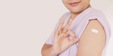 Vaccination Campaign,  Vaccinated Immunity Concept. Asian Woman Getting Vaccine Inoculation for Healthy and Immunization While Giving Ok Sign With Copy Space. Vaccination Campaignsの写真素材