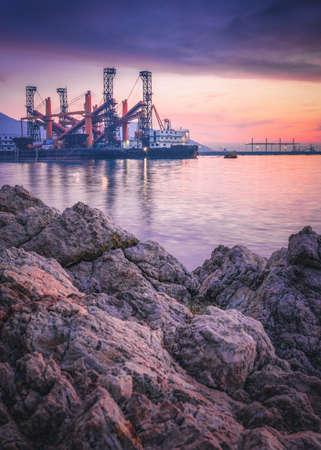 Shipping Port and Marine Service Industry, Logistics Maritime Ship Seashore at Sunset. Nature Landscape of Seascape and Marine Dock Services for Heavy Industrial. Commercial Dock for Transportationの写真素材