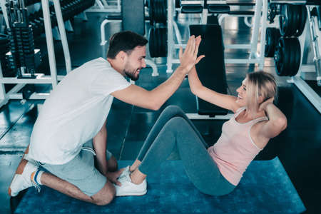 Attractive fitness couple love giving high five together after workout in fitness gym., Portrait of man and woman sporty are working out training together., Couple fitness and healthy concept.の写真素材