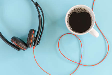 Coffee Break and Work Lifestyle Concept, Coffee Cup and Headphone Set on Isolate Blue Background. Coffee Lifestyles and Office Media Creative Design Content, Accessory Electronic Device Headphonesの写真素材