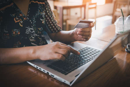 Business Credit Banking and Online Shopping Service, Close-Up of Business Woman Hands Using Credit Card for Paying Online Shopping on E-Commerce Web in Coffee Shop. Shopping Payment Via Credit Cardの写真素材