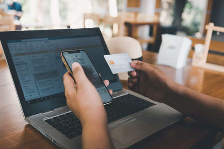 Business Credit Banking and Online Shopping Service, Close-Up of Business Woman Hands Using Credit Card for Paying Online Shopping on E-Commerce Web in Coffee Shop. Shopping Payment Via Credit Cardの写真素材