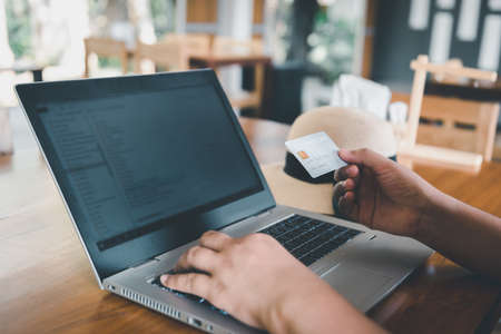Business Credit Banking and Online Shopping Service, Close-Up of Business Woman Hands Using Credit Card for Paying Online Shopping on E-Commerce Web in Coffee Shop. Shopping Payment Via Credit Cardの写真素材