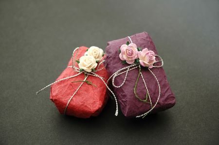 Gift wrapped in purple and pink with decorative flowers and silver ribbon