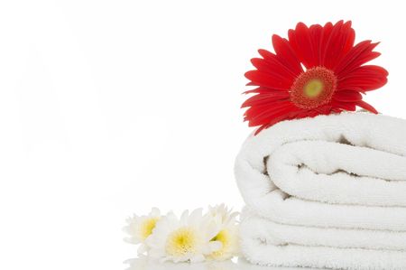 wellness concept with towel and red daisy flower on white background, space for messagesの写真素材