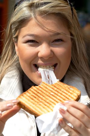 young happy girl with toasted sandwich at restaurant