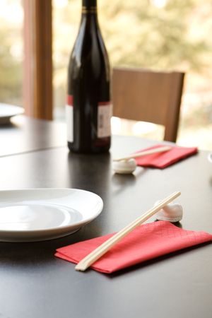japanese food restaurant with chopsticks, empty plate and wine bottleの写真素材