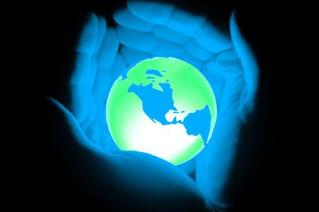 a hand holding globe world in dark