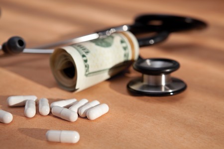 stethoscope, medical pills and US dollars close up on old paperの写真素材