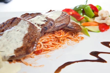 Beef steaks garnished with salad , and sauceの写真素材