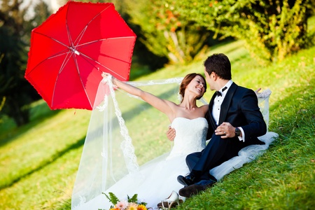 happy bride and groom at a park on their wedding dayの写真素材