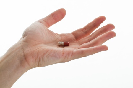 hand holding medical pill on whiteの写真素材
