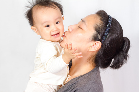 Asian mom holding baby in white backgroundの写真素材