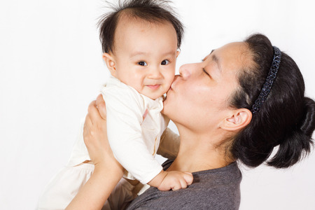 Asian mom holding baby in white backgroundの写真素材
