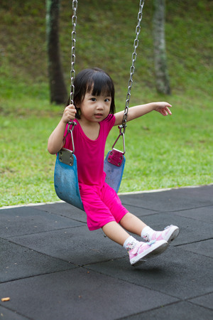 Asian Chinese little girl swing at outdoor park.の写真素材