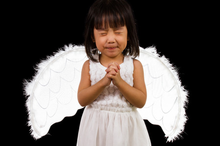 Asian Chinese Little Angel in black background studio shot.の写真素材